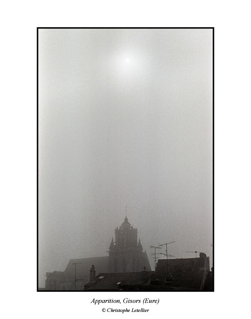 Photo noir et blanc de la galerie " Haute Normandie". Eglise Saint Gervais-Saint Protais  de Gisors ( XII &egrave;me si&egrave;cle) avec son clocher sous la brume et la perc&eacute;e de l'astre solaire. &copy; Mars 2005 Christophe Letellier, tous droits r&eacute;serv&eacute;s.