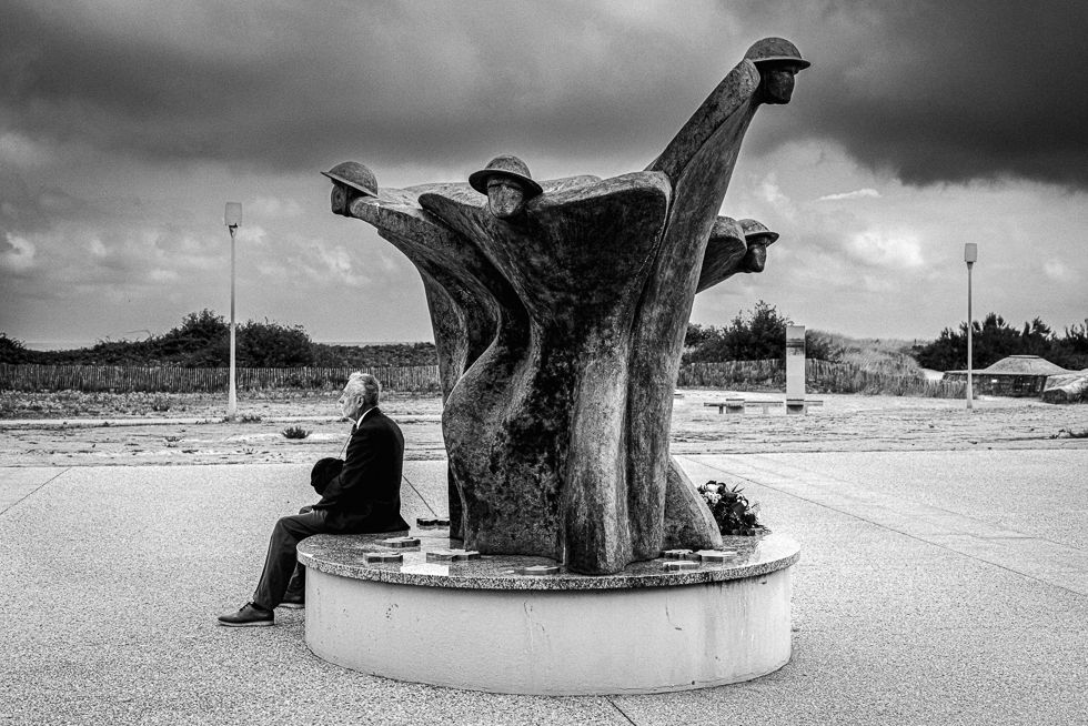 Photo en noir et blanc d'un patriote canadien se recueillant au Centre Juno Beach de Courceulles-sur-Mer. © 2022 Christophe Letellier tous droits réservés. 