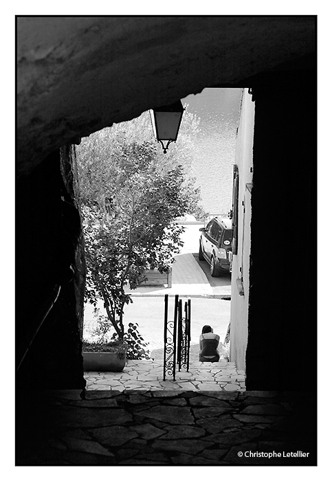 "BAUDUEN". Photo noir et blanc d'une jeune femme en train d'écrire un texto sur son mobile dans une rue de Bauden. © juillet 2010 Christophe Letellier tous droits réservés. 
